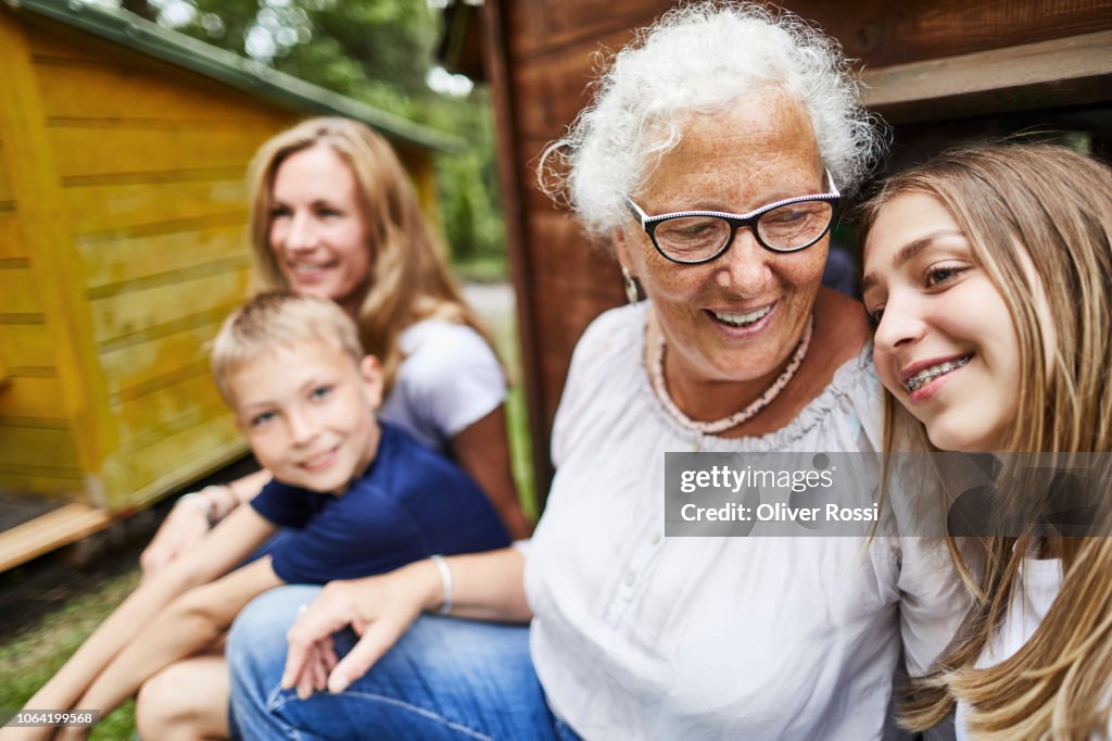 Happy extended family sitting at a hut in an amusement park