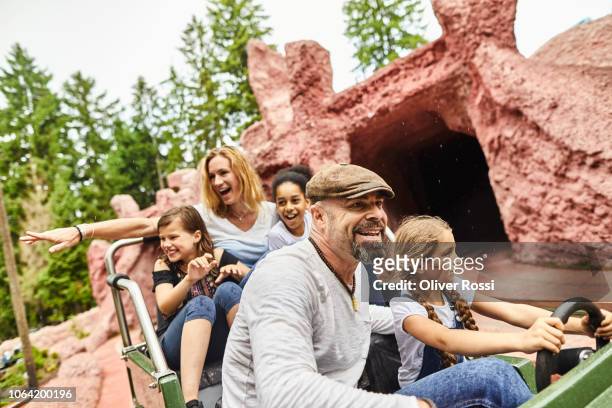 happy family in an amusement park ride - amusement ride stock pictures, royalty-free photos & images