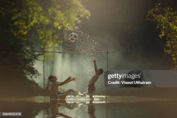 asian children playing football at the river. - kids at river stock-fotos und bilder