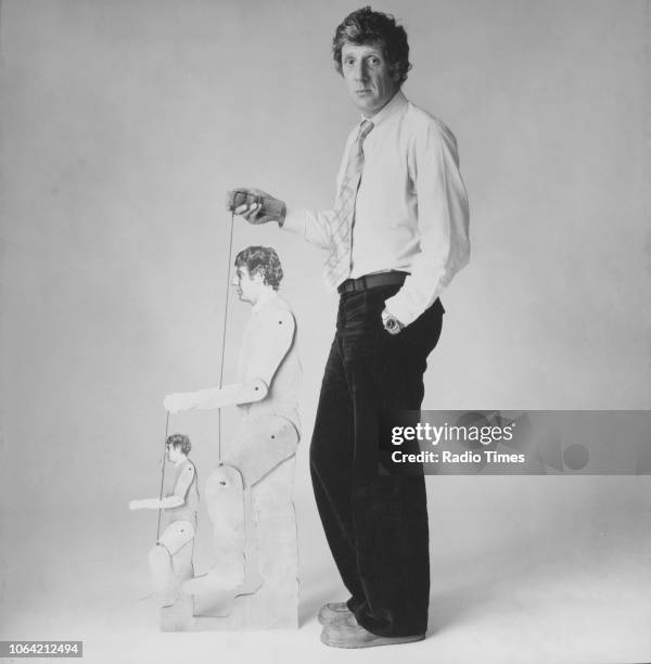 Portrait of theatre director Jonathan Miller holding the strings of two marionettes in his own likeness, circa 1975.