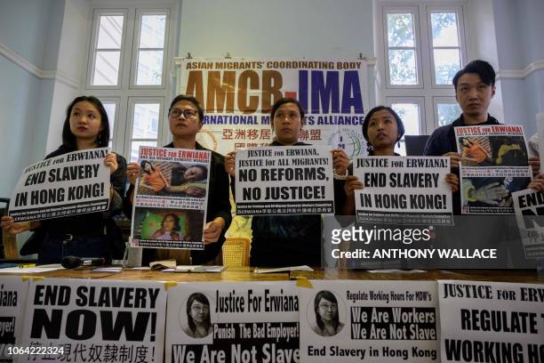 Indonesian Tutik Lestari Ningsih , an abuse victim of recently freed former employer Law Wan-tung, holds up a poster in support of former Indonesian...