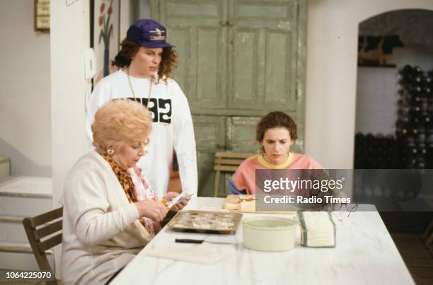 Actresses June Whitfield, Jennifer Saunders and Julia Sawalha sitting around the kitchen table in a scene from episode 'Fat' of the television sitcom...