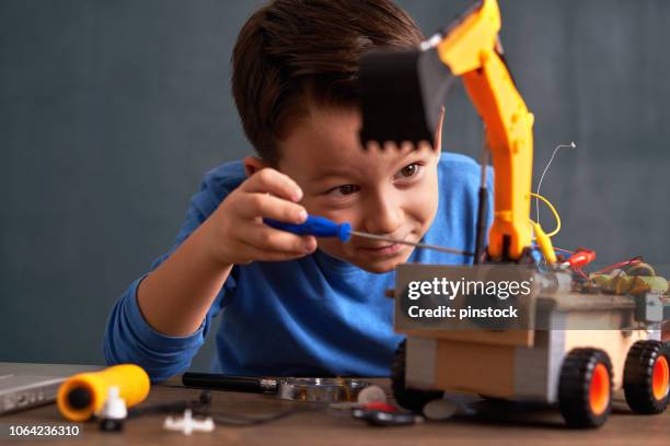 niño de escuela primaria edad construye robot - genius fotografías e imágenes de stock