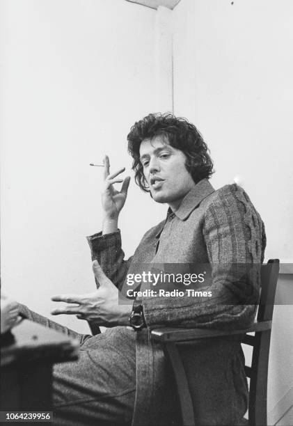 Portrait of playwright Tom Stoppard sitting at a table and smoking a cigarette, photographed by Radio Times for the magazine feature 'My Choice' in...