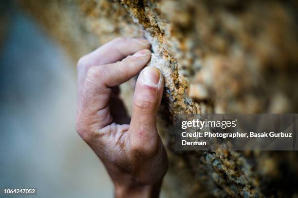close-up of climber`s hand holding on to rock. - chalk rock stock pictures, royalty-free photos & images