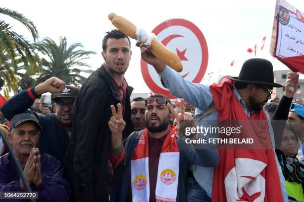 Tunisian protester holds up a loaf of bread during a civil servants general strike after the failure of negotiations with the government on salary...
