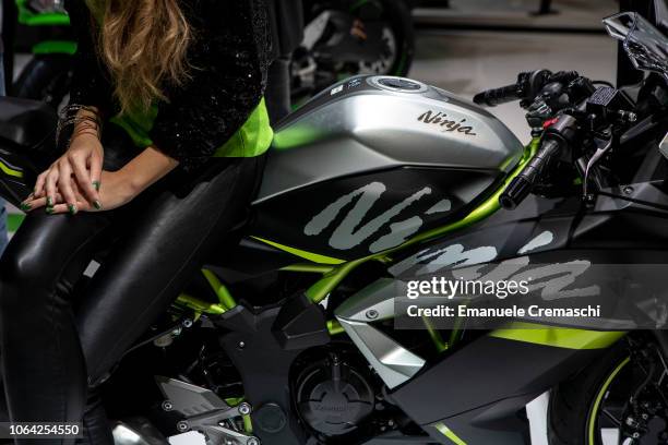 Stewardess sits on the saddle of a Kawasaki Ninjia motorcycle during the 76th edition of EICMA on November 6, 2018 in Milan, Italy. EICMA is an...