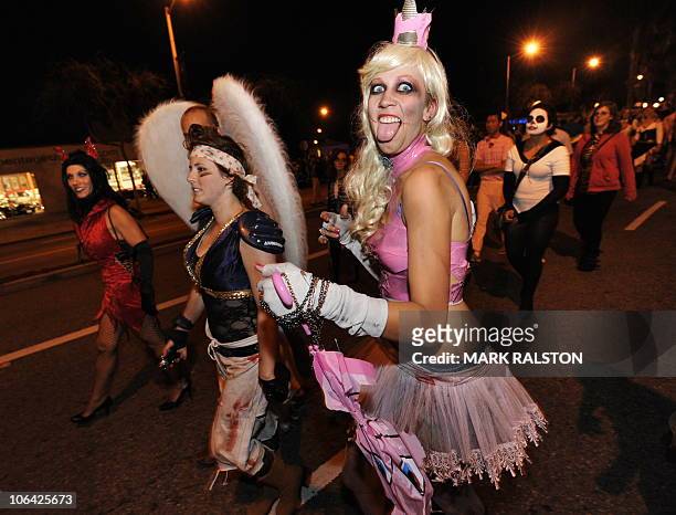 Revellers pose for photos as they parade along Santa Monica Blvd during the annual Halloween Carnaval in West Hollywood on October 31, 2010....