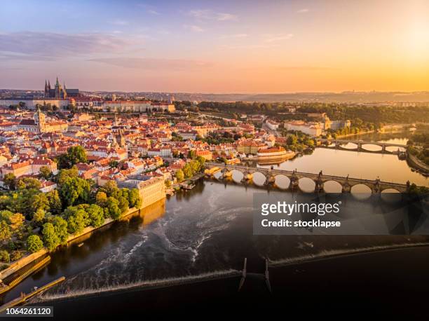 vue aérienne du château de prague, la cathédrale et du pont charles au lever du soleil à prague - rivière vltava photos et images de collection