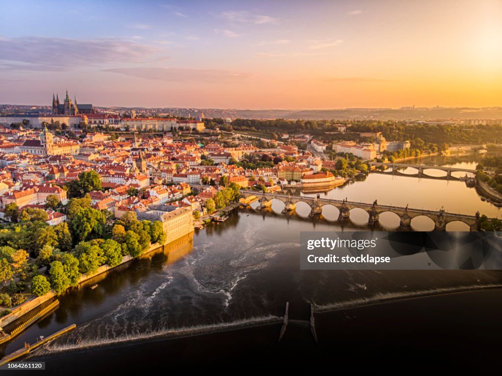 Aerial view of Prague Castle, cathedral and Charles Bridge at sunrise in Prague