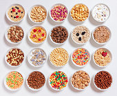 set of different cereals with milk on a white background