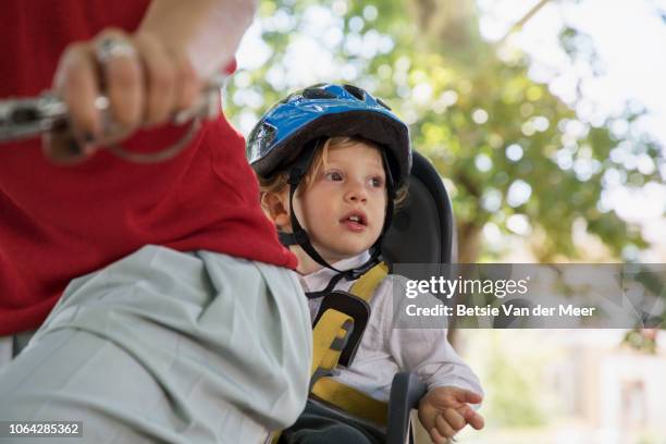 close up of mother cycling with toddler in bicycle seat. - familie fietsen close up stockfoto's en -beelden