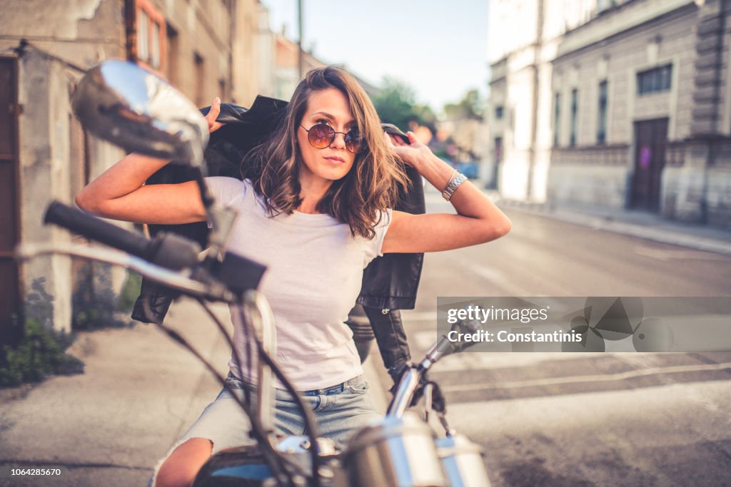 Giovane ragazza piuttosto modellata seduta sulla sua moto