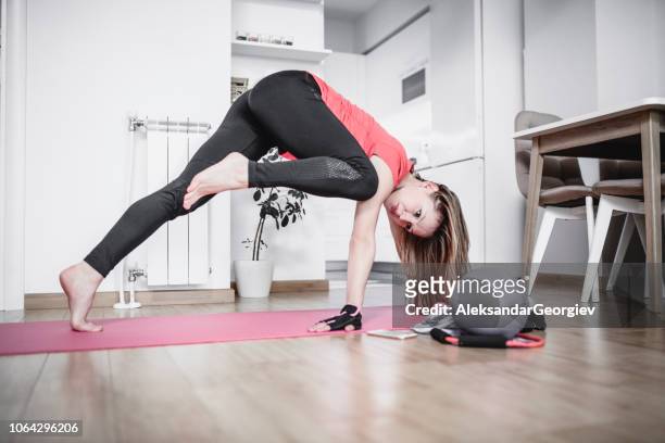 女運動員在客廳裡做一腿伸展運動 - yoga ball work 個照片及圖片檔