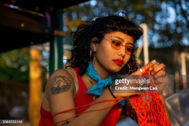 young woman knitting in park - knitting stock pictures, royalty-free photos & images