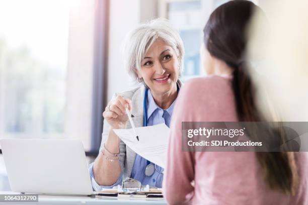 doctor reviews patient's test results - showing pen stock pictures, royalty-free photos & images