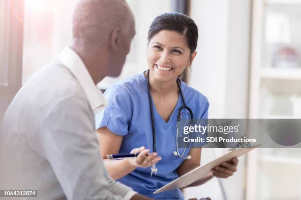 female doctor shares test results with senior patient - clipboard stock pictures, royalty-free photos & images