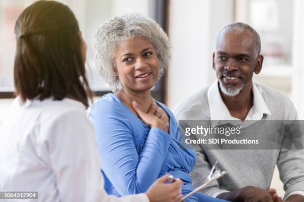 senior couple receive good news from doctor - couple doctor stock pictures, royalty-free photos & images