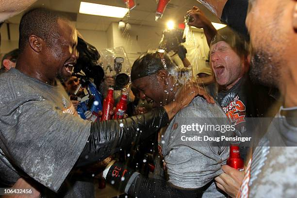 Edgar Renteria of the San Francisco Giants celebrates with his teammates in the locker room after the Giants won 3-1 against the Texas Rangers in...