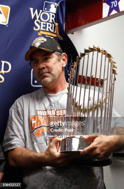 Manager Bruce Bochy of the San Francisco Giants celebrates with the World Series trophy in the locker room after the Giants won 3-1 against the Texas...
