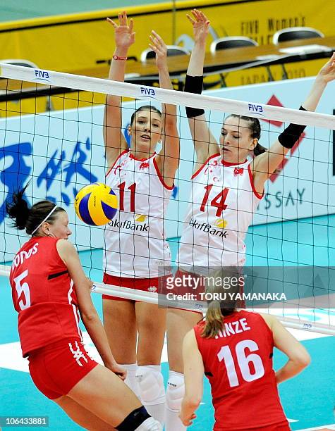 Naz Aydemir and Eda Erdem of Turkey block a spike from Tiffany Dodds and Jennifer Hinze of Canada during their first round match of the World Women's...