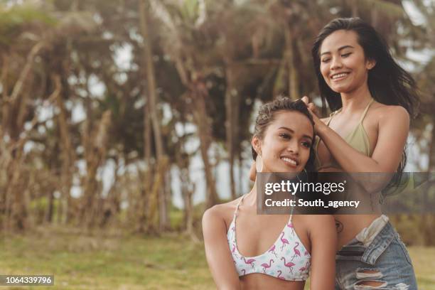lesbian couple sitting at beach - indian lesbian stock pictures, royalty-free photos & images