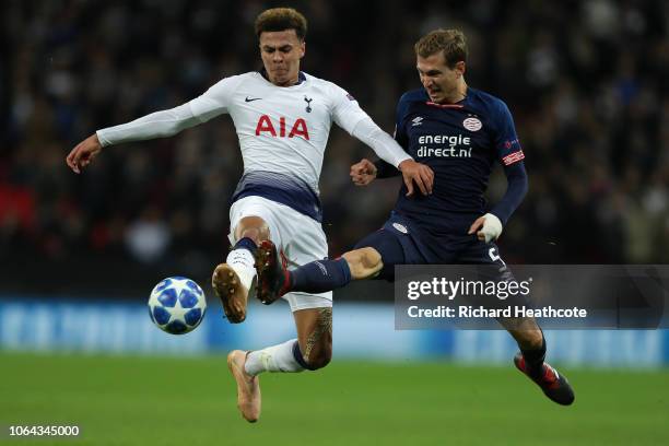 Dele Alli of Tottenham is challenged by Daniel Schwaab of PSV during the Group B match of the UEFA Champions League between Tottenham Hotspur and PSV...