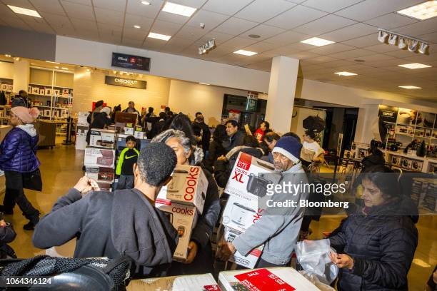 Shoppers carry their Black Friday deals at a J.C. Penney Co. Store in Garden City, New York, U.S., on Thursday, Nov. 22, 2018. Deloitte expects sales...
