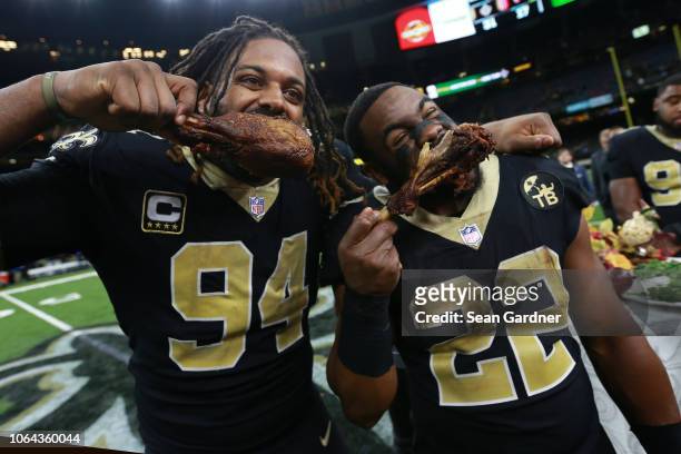 Cameron Jordan of the New Orleans Saints and Mark Ingram eat turkey after a game against the Atlanta Falcons the Mercedes-Benz Superdome on November...