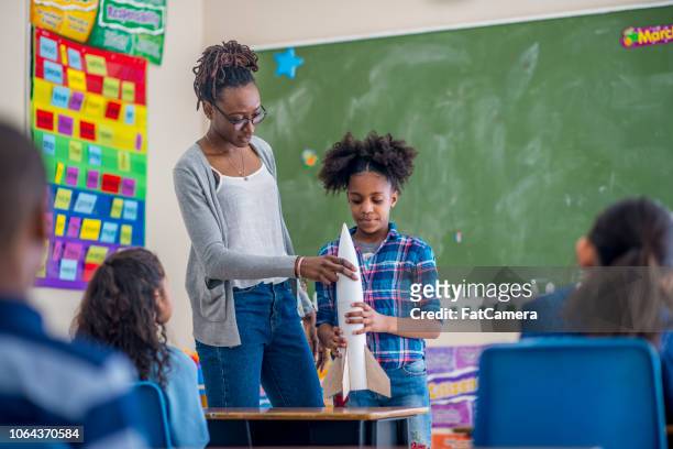 teacher assisting student - model rocket stock pictures, royalty-free photos & images