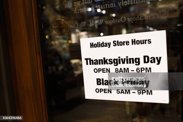 Store opening hours for Thanksgiving and Black Friday sit on display on the door of a Bass Pro Outdoor World LLC store on Black Friday in Tampa,...