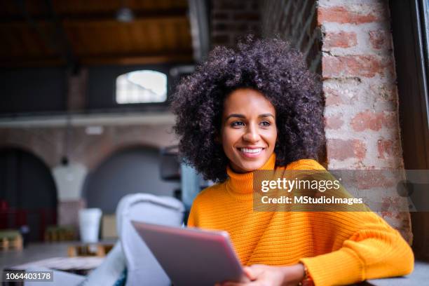 donna sorridente che usa il tablet digitale. - daily life in brazil foto e immagini stock