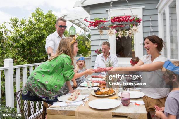 a mother and daughter pull a christmas cracker at the table - new zealand christmas stock pictures, royalty-free photos & images