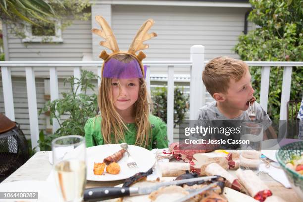 siblings sit eating at the christmas lunch table - christmas crackers stock pictures, royalty-free photos & images