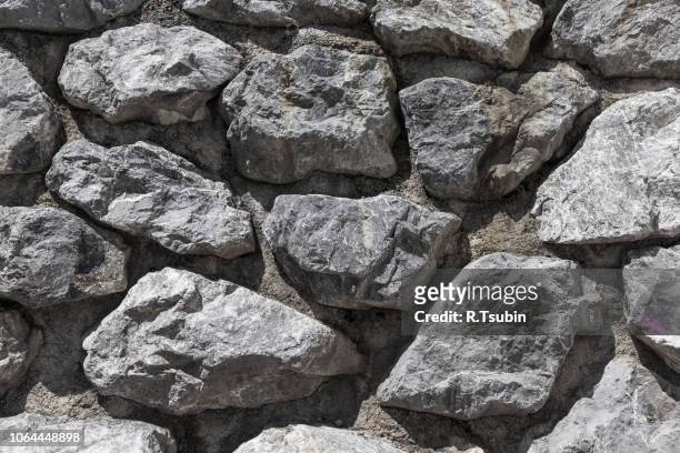 stone rock wall for background and texture - rohbau haus stock-fotos und bilder