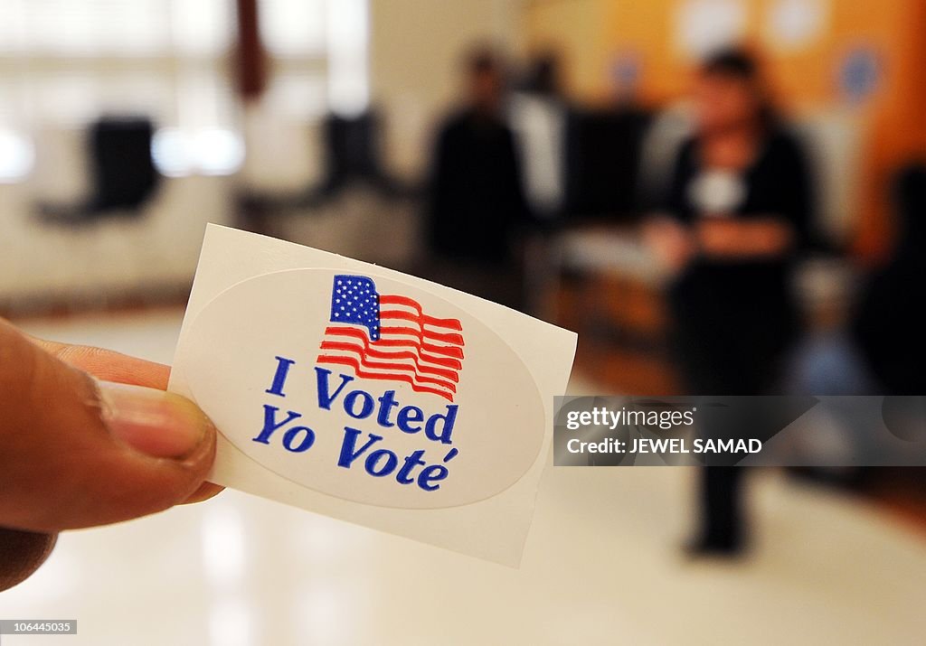 A man shows "I voted" sticker as others