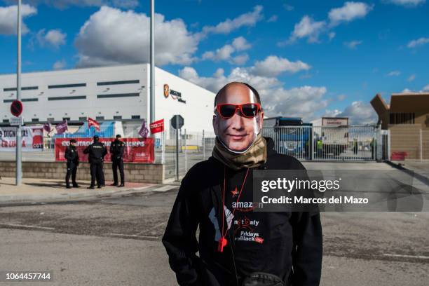 An Amazon worker with a mask of Amazon founder Jeff Bezos posing during a strike on "Black Friday" in the main logistic center protesting demanding...