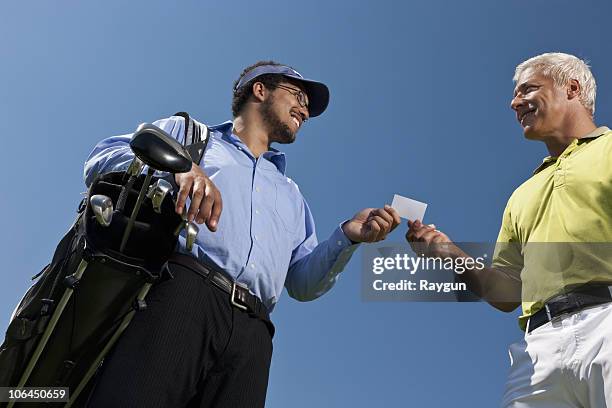 golfer giving his card to the caddy - golf caddy stock-fotos und bilder