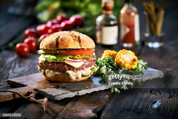 hemmagjord läckra hamburgare på åldern träbord - hamburger bildbanksfoton och bilder