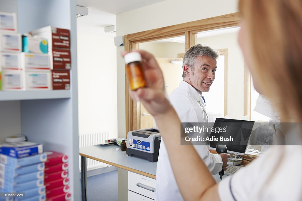 Pharmacist looking at pills in bottle