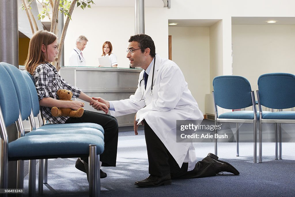 Doctor greeting young girl in surgery