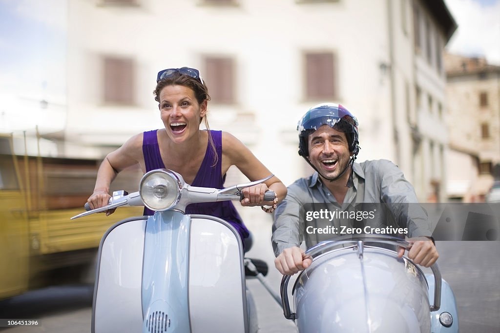 Couple driving a vespa