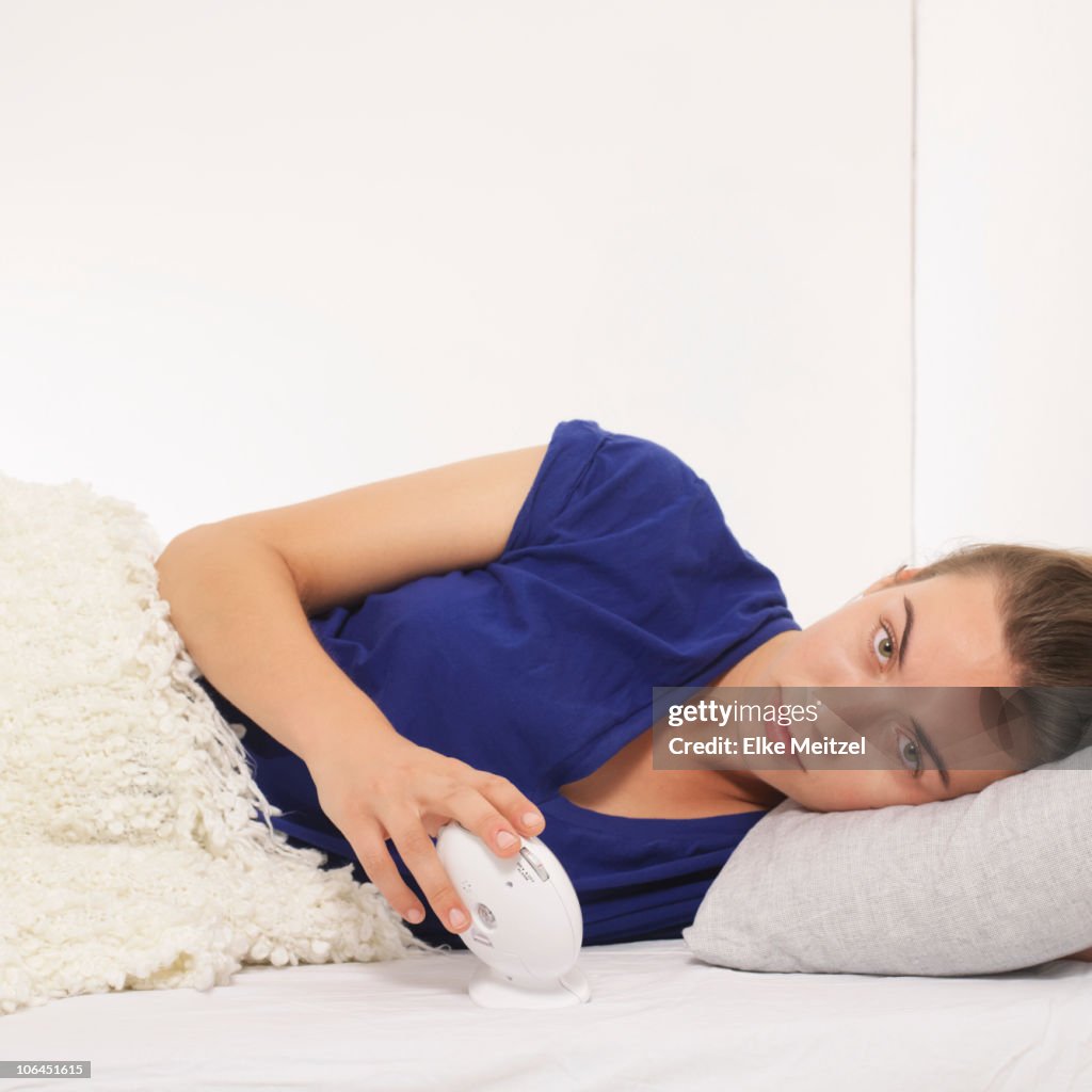 Woman reclined with alarm clock