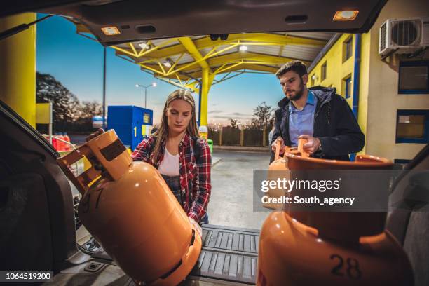 young couple buying lpg gas bottle - canister stock pictures, royalty-free photos & images