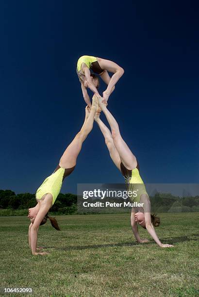 acrobatic troop performing moves - acrobatics gymnastics stockfoto's en -beelden