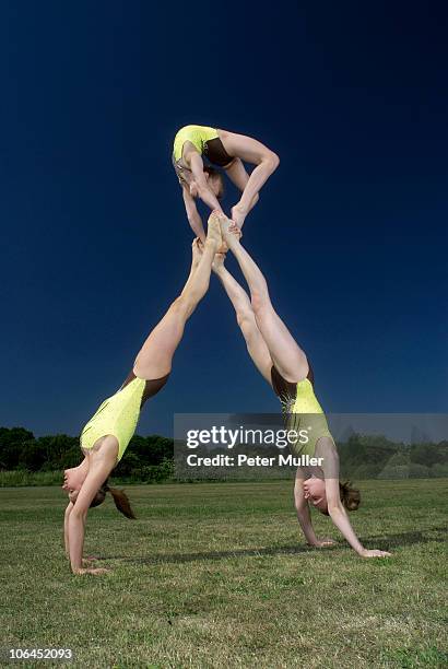 acrobatic troop performing moves - acrobatics gymnastics stock pictures, royalty-free photos & images