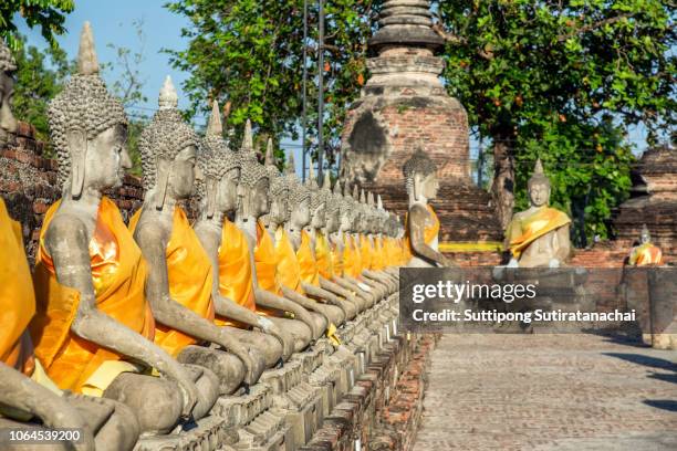 line of buddha statue image in wat yai chaimongkol , ayutthaya , thailand - wat imagens e fotografias de stock