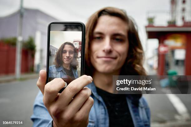 young man taking a selfie. - eitelkeit stock-fotos und bilder