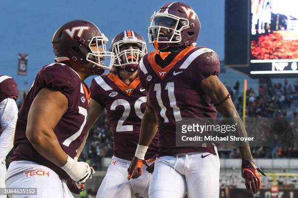 Wide receiver Tre Turner of the Virginia Tech Hokies celebrates his touchdown reception against the Virginia Cavaliers with tight end Dalton Keene...