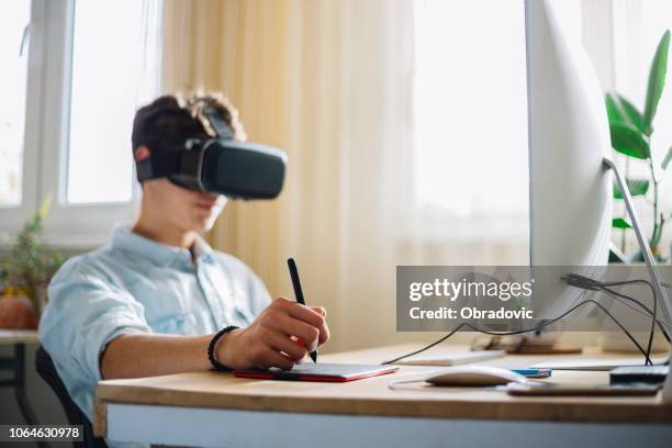 in een computer science klasse jongen dragen van virtual reality headset werkt aan een project programing - virtual reality glasses stockfoto's en -beelden